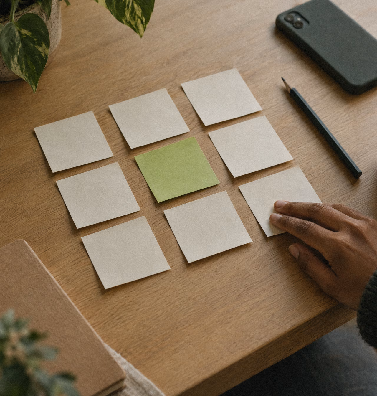 Sticky notes sorted into three columns on an oak table.